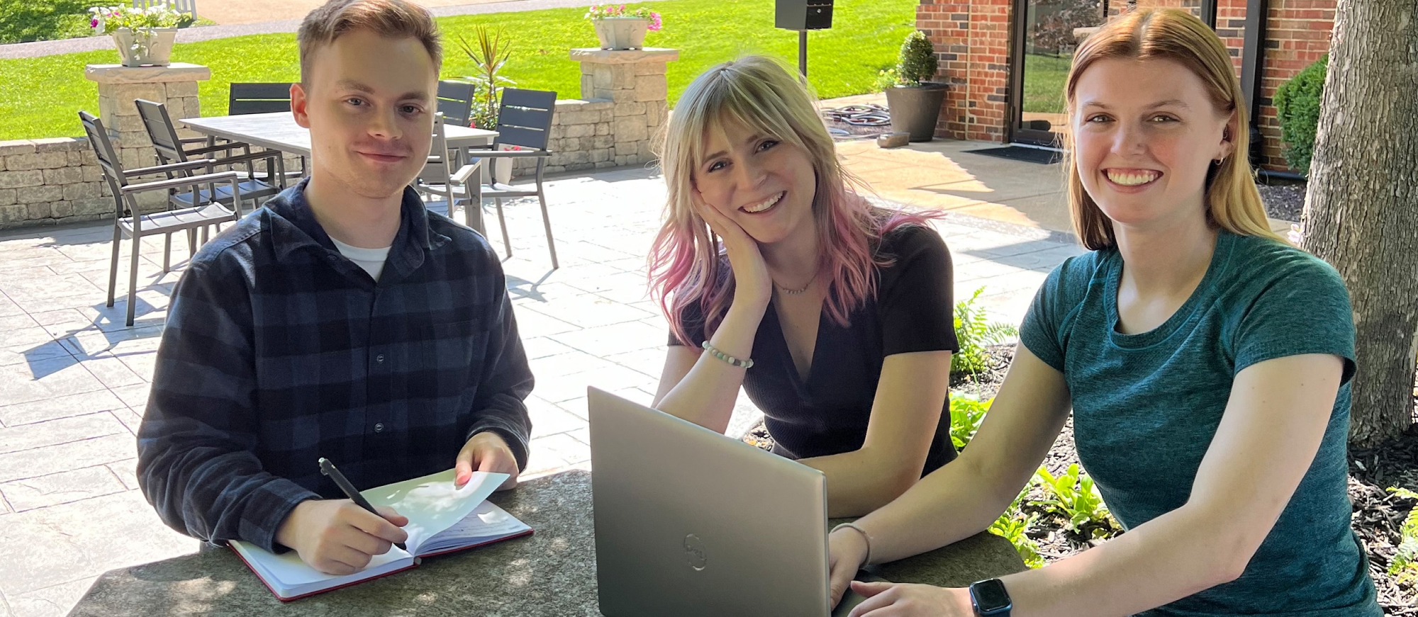 Interns sitting outdoors.