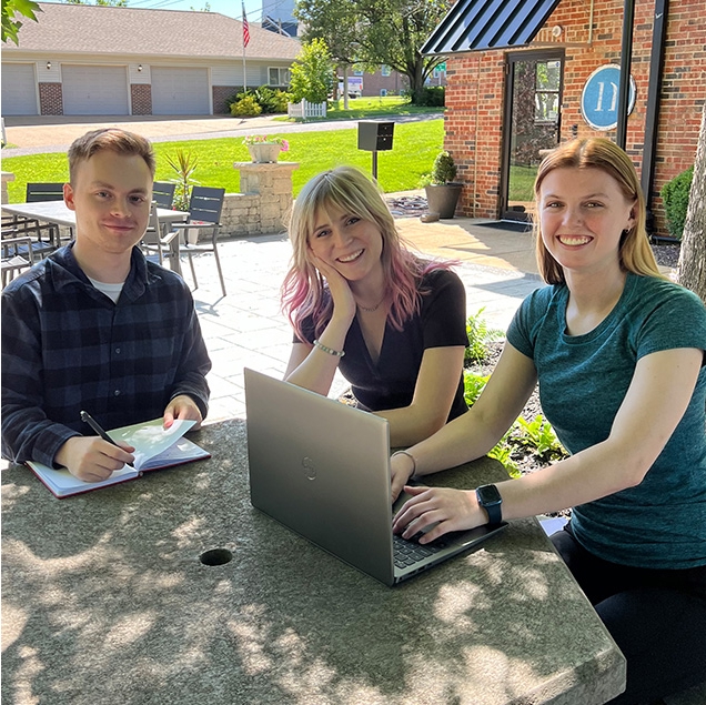 Interns sitting outdoors.