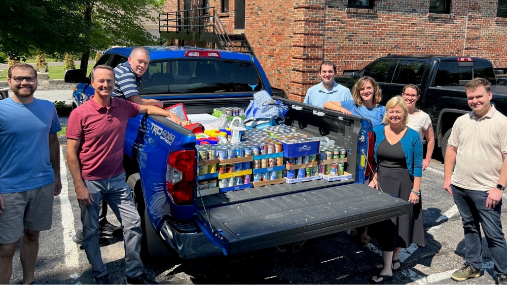 Team members around a truck full of donated items.